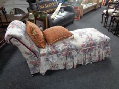 A storage chaise longue upholstered in a floral fabric