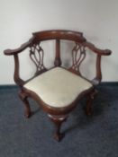 A reproduction mahogany corner armchair on claw and ball feet.