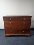 A 19th century five drawer chest with circular brass drop handles on bracket feet.