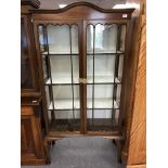 An Edwardian mahogany arch topped double door display cabinet on legs.