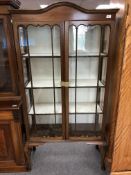 An Edwardian mahogany arch topped double door display cabinet on legs.