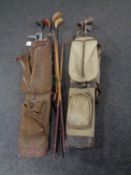 Two mid 20th century canvas golf bags containing golf clubs to include hickory shafted drivers and