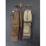 Two mid 20th century canvas golf bags containing golf clubs to include hickory shafted drivers and