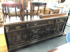 A 19th century oak four door three drawer sideboard with carved panel doors and mask faces.