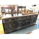 A 19th century oak four door three drawer sideboard with carved panel doors and mask faces.