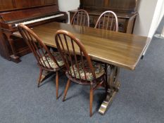 An oak refectory dining table together with a set of four Ercol solid elm and beech high backed