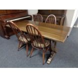 An oak refectory dining table together with a set of four Ercol solid elm and beech high backed