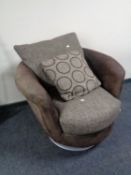 A swivel lounge armchair in a two tone brown fabric.