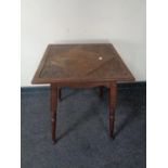 A carved Edwardian oak occasional table on tapered legs.