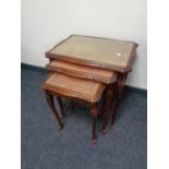 A nest of three leather topped tables