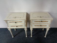 A pair of painted cream and gilt two drawer bedside chests on reeded legs.