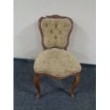 A beech framed French occasional chair upholstered in floral fabric on cabriole legs