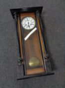 An early 20th century eight day wall clock with brass and enamelled dial.