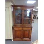 An Edwardian mahogany double door glazed bookcase, fitted cupboard and drawers beneath.