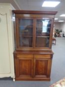An Edwardian mahogany double door glazed bookcase, fitted cupboard and drawers beneath.