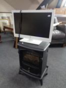 An electric heater in the form of a stove together with a Bush 22" LCD TV with remote