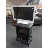 An electric heater in the form of a stove together with a Bush 22" LCD TV with remote