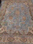 A fringed woolen machine made carpet of Persian design on blue ground, 365cm by 254cm.