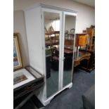 A painted Ducal pine double door mirrored wardrobe