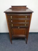 An Edwardian mahogany music cabinet fitted cupboard and three drawers with brass drop handles