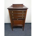 An Edwardian mahogany music cabinet fitted cupboard and three drawers with brass drop handles