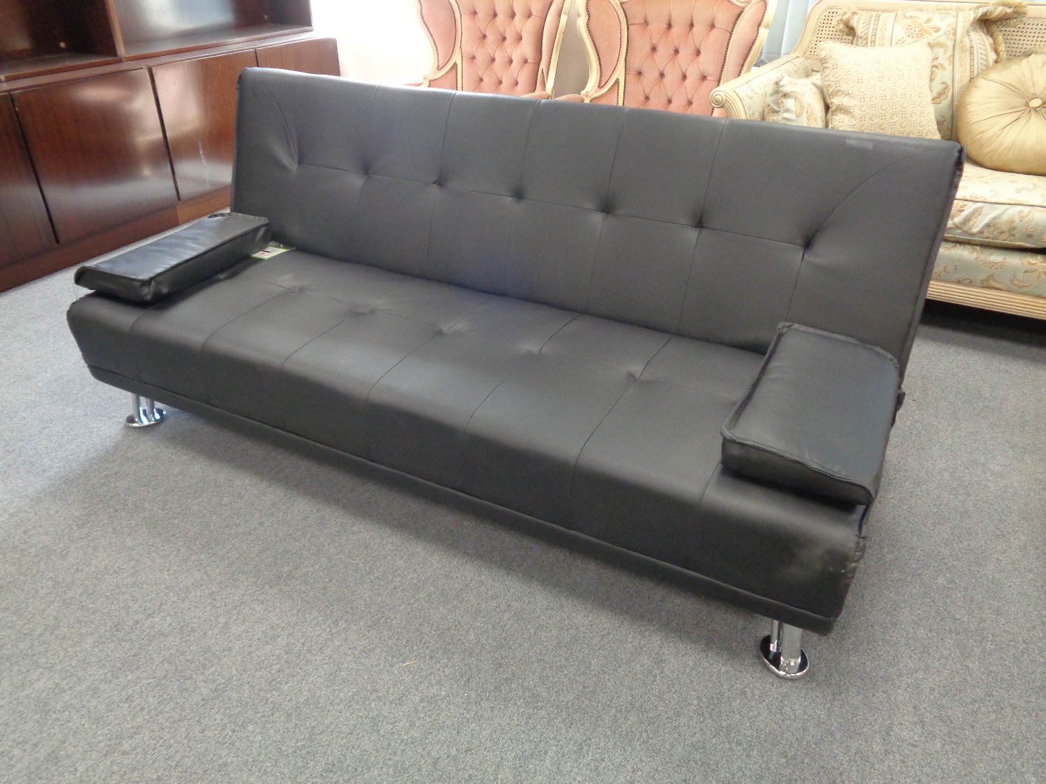 A black faux leather folding sofa bed, boxed.