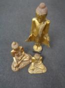 Two giltwood figures of seated Buddha's, together with a further gilt figure of a Buddha.