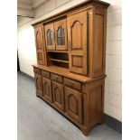 A 20th century oak dresser fitted eight cupboards and four drawers with brass bow handles,