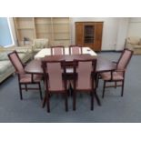 A 20th century Stouby twin pedestal extending dining table with two leaves and six chairs,