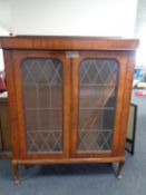 A late 19th century mahogany double door bookcase with leaded glass doors on raised Queen Anne legs