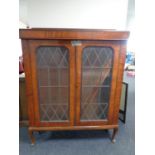 A late 19th century mahogany double door bookcase with leaded glass doors on raised Queen Anne legs