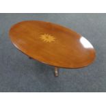 An inlaid oval pedestal coffee table.