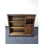 A set of oak open bookshelves, fitted cupboard and drawer.