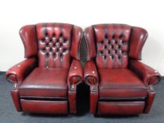 A pair of red buttoned leather Chesterfield wingback reclining armchairs