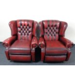 A pair of red buttoned leather Chesterfield wingback reclining armchairs