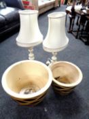 A pair of circular glazed pottery graduated garden planters together with a pair of table lamps