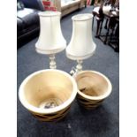 A pair of circular glazed pottery graduated garden planters together with a pair of table lamps