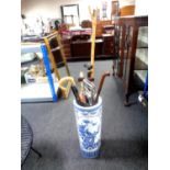 A blue and white oriental style stick stand containing assorted walking and shooting sticks