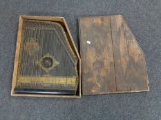 An antique Anglo-American guitar zither in a pine box.