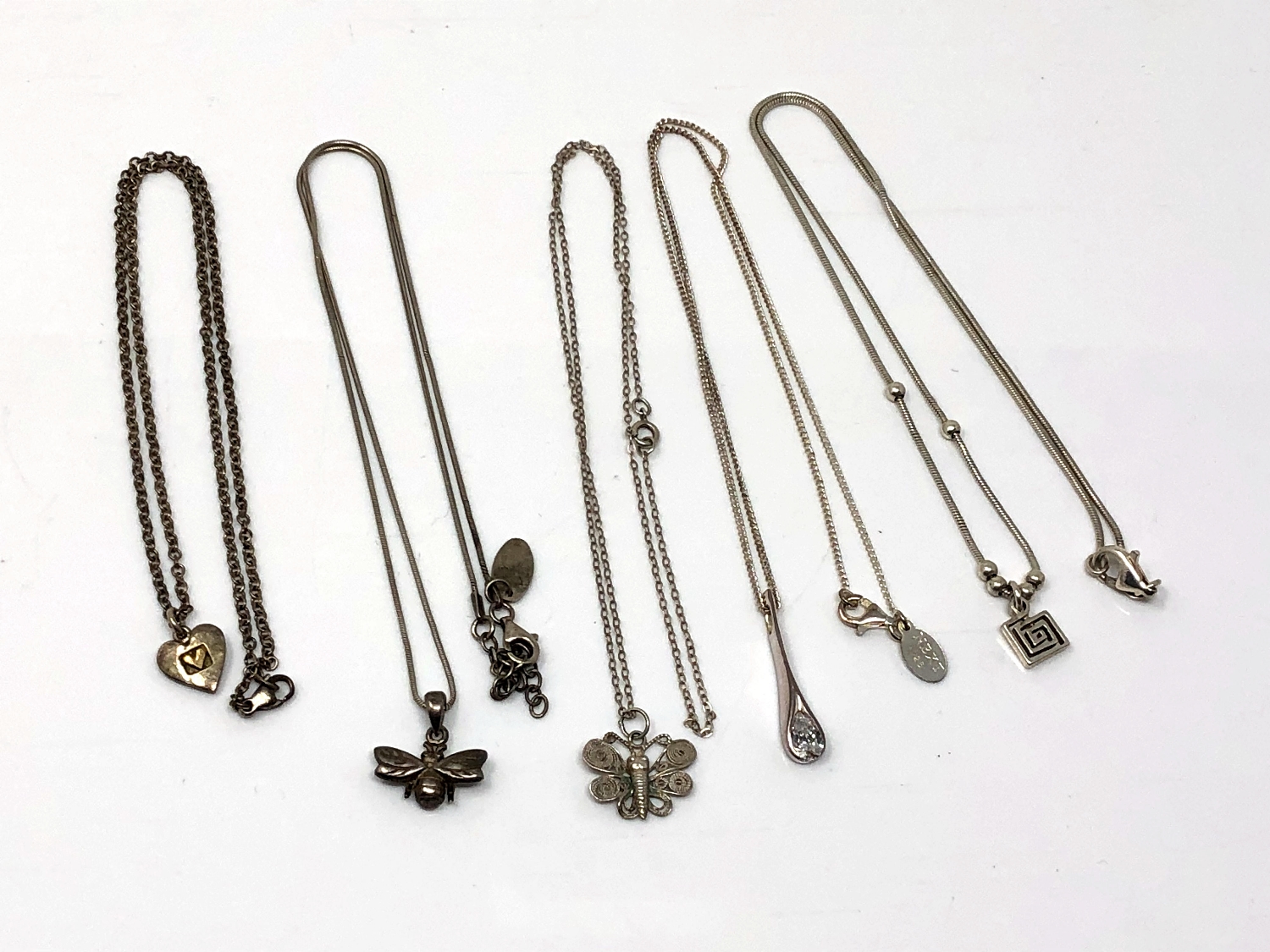 Five silver pendants/necklaces.