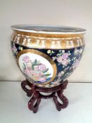 A Chinese style floral fish bowl planter on stand.