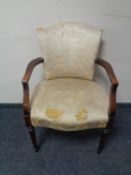 A twentieth century beech framed armchair upholstered in cream brocade fabric (for restoration)