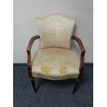 A twentieth century beech framed armchair upholstered in cream brocade fabric (for restoration)