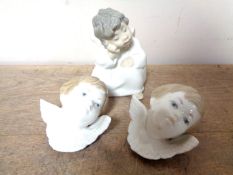 A Lladro figure of a cherub and two Lladro cherub masks CONDITION REPORT: One mask