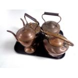 Three antique copper kettles together with a copper teapot.