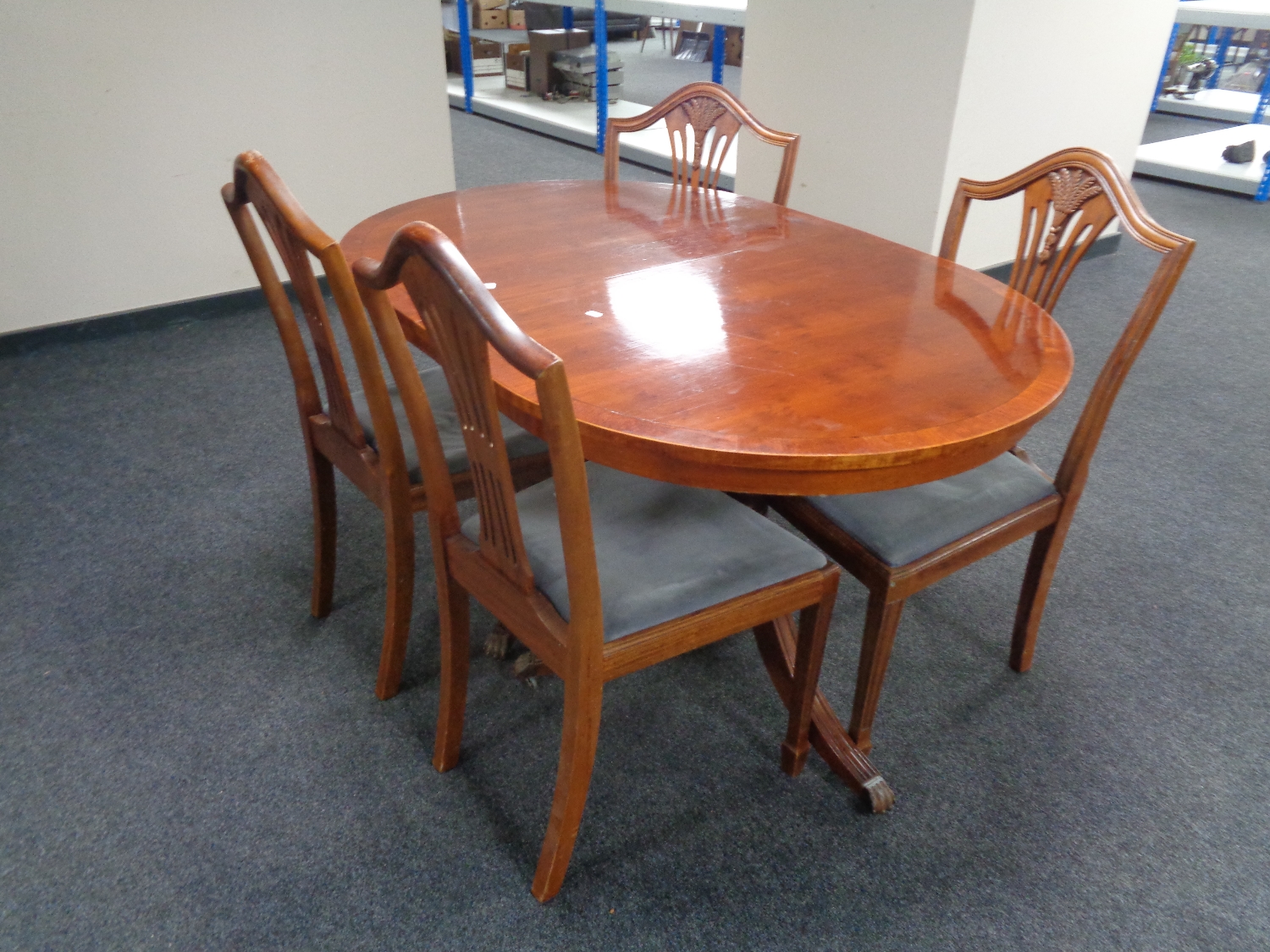 An inlaid yew wood twin pedestal dining table together with a set of four shield back chairs