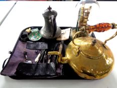 A tray containing antique pewter teapot, brass kettle, a Kundo anniversary clock under shade,