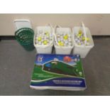 Three tubs containing a large quantity of golf balls together with a putting machine