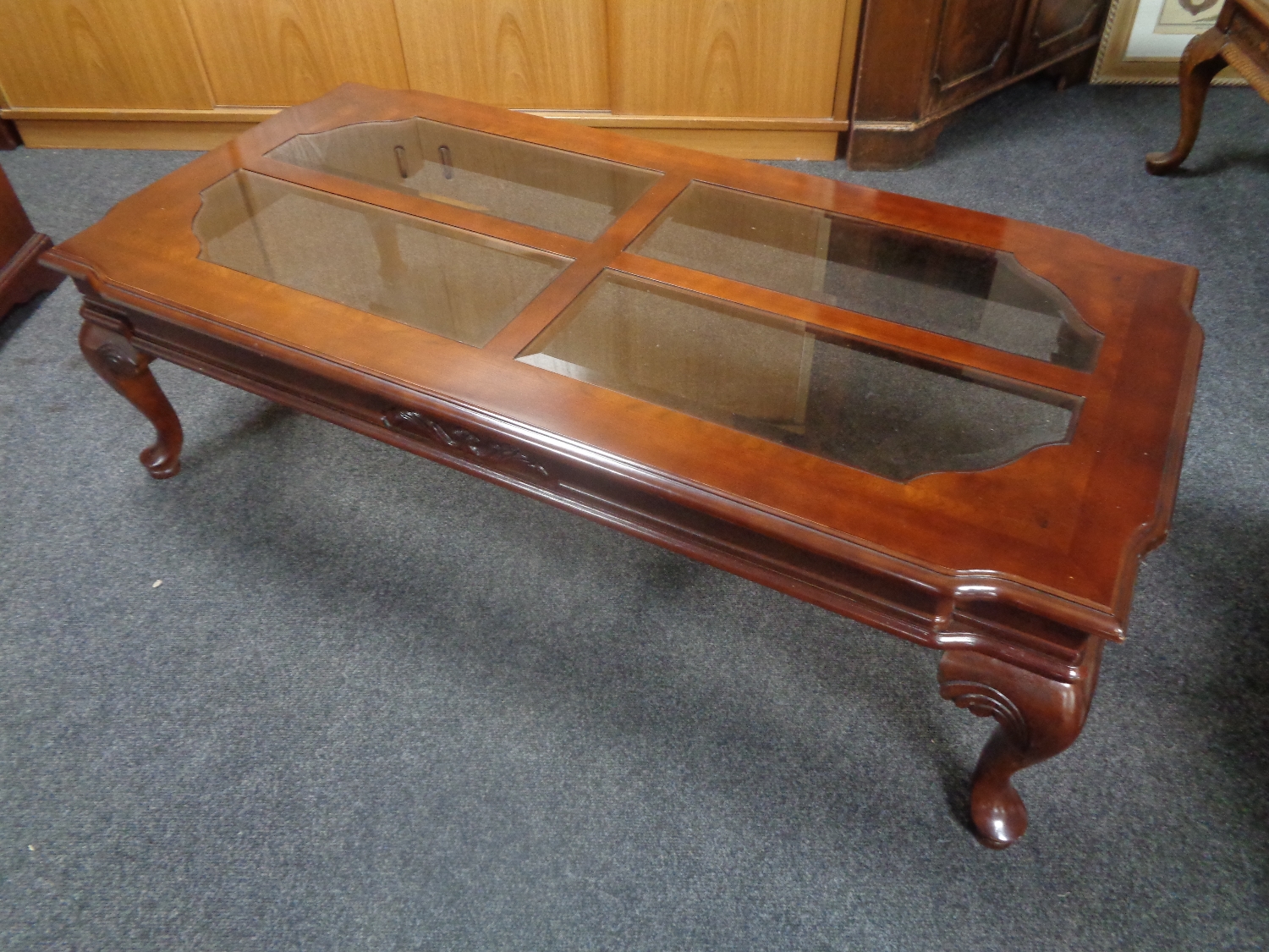 A contemporary rectangular coffee table on cabriole legs with four glass inset panels