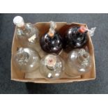 A box containing six glass demijohns.